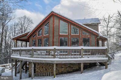 view of snow covered exterior with a wooden deck