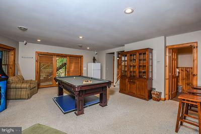 recreation room with light colored carpet and pool table