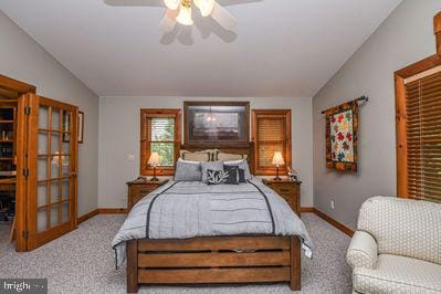 carpeted bedroom featuring ceiling fan and vaulted ceiling