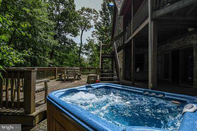 wooden terrace featuring a hot tub