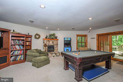 rec room featuring light colored carpet, a fireplace, and billiards