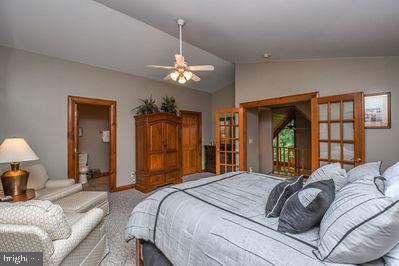 bedroom with ceiling fan, lofted ceiling, light carpet, and french doors