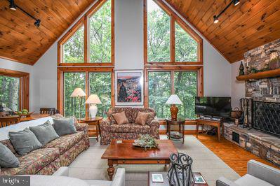 living room with track lighting, high vaulted ceiling, ceiling fan, and wooden ceiling