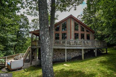 rear view of house with a deck and a lawn