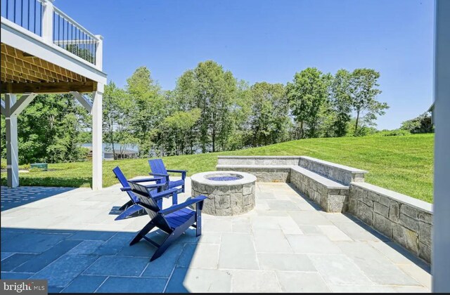 view of patio featuring a fire pit and a balcony