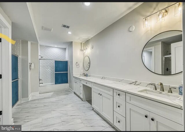 bathroom featuring a shower with door and vanity