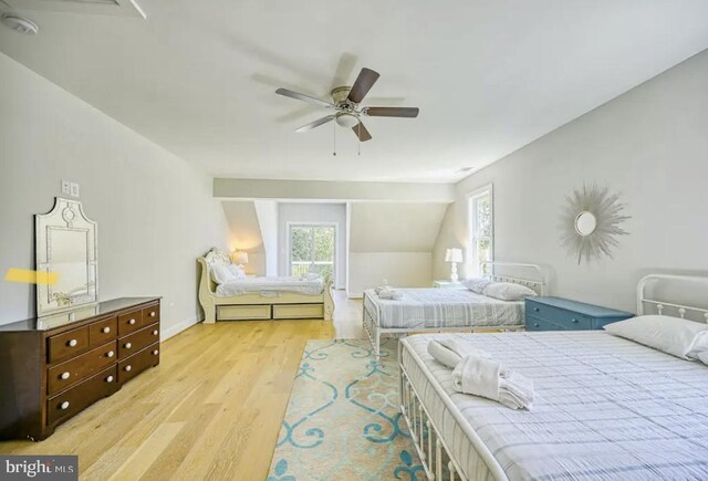 bedroom featuring light wood-type flooring, ceiling fan, and vaulted ceiling