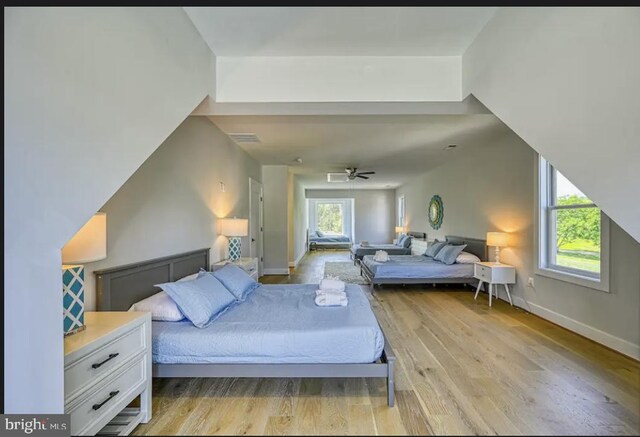 bedroom featuring multiple windows, light hardwood / wood-style flooring, and ceiling fan