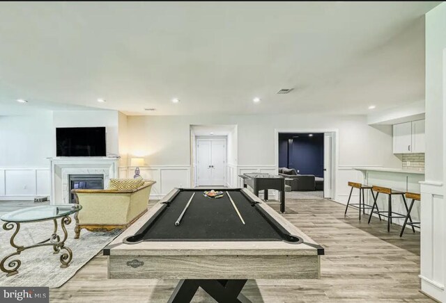 rec room featuring billiards, a premium fireplace, and light wood-type flooring