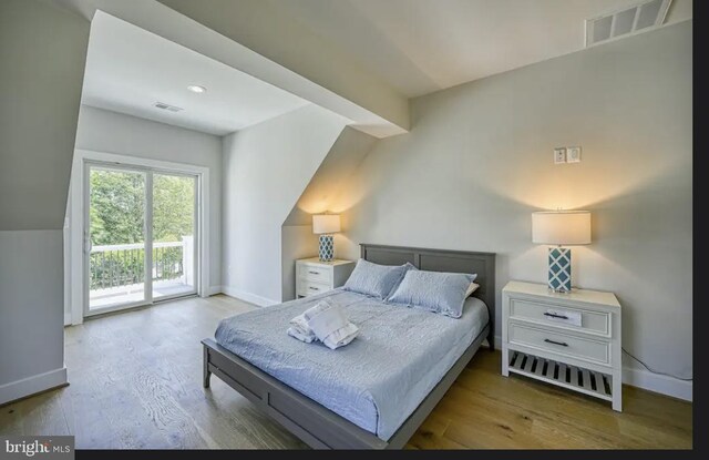 bedroom with access to exterior, light hardwood / wood-style floors, and lofted ceiling