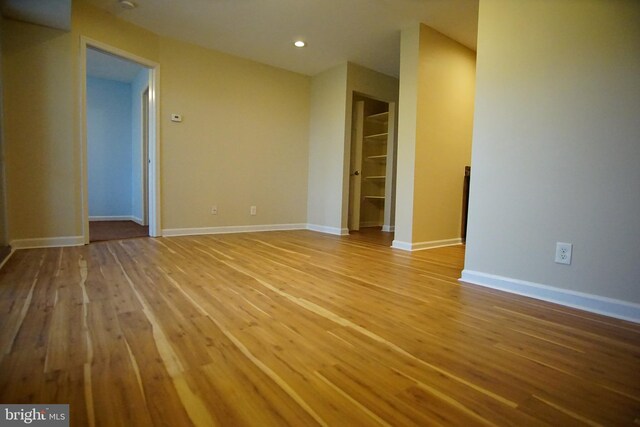 spare room with recessed lighting, baseboards, and wood finished floors