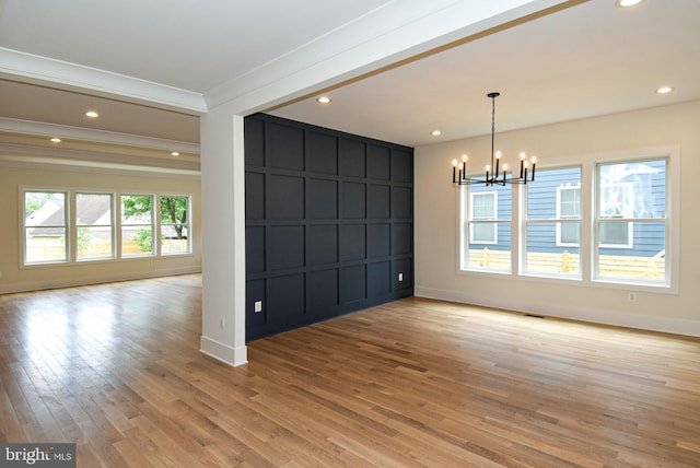 interior space featuring ornamental molding, light hardwood / wood-style floors, and a notable chandelier