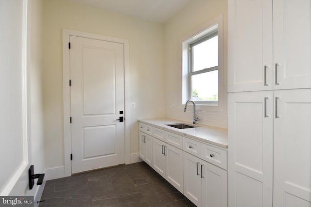 kitchen featuring backsplash, white cabinetry, and sink