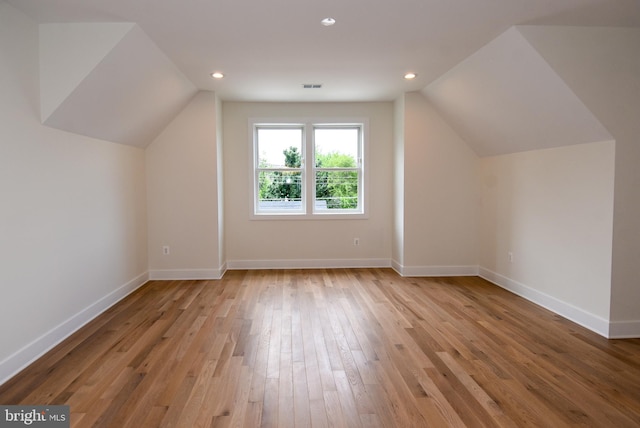 bonus room with light hardwood / wood-style flooring and lofted ceiling