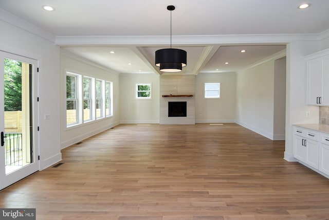 unfurnished living room featuring a high end fireplace, light hardwood / wood-style flooring, and ornamental molding