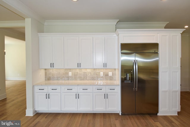 kitchen featuring white cabinets, stainless steel built in refrigerator, and light wood-type flooring