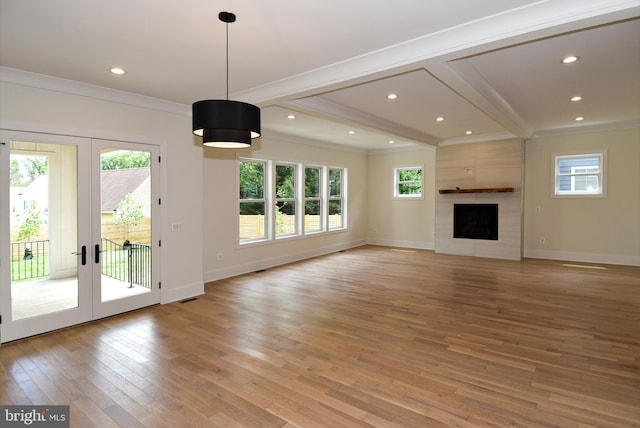 unfurnished living room with a tile fireplace, a wealth of natural light, light hardwood / wood-style flooring, and crown molding