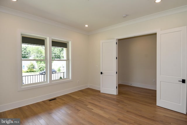 unfurnished bedroom with hardwood / wood-style flooring and crown molding