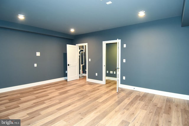 unfurnished bedroom with light hardwood / wood-style floors, a spacious closet, and a closet