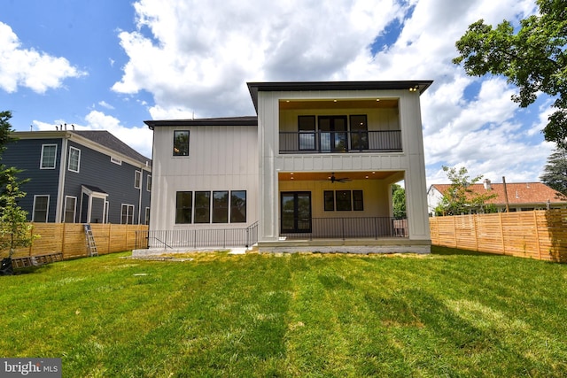 back of house featuring a yard, a balcony, and ceiling fan