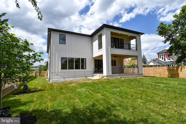 back of house with a lawn, ceiling fan, and a balcony