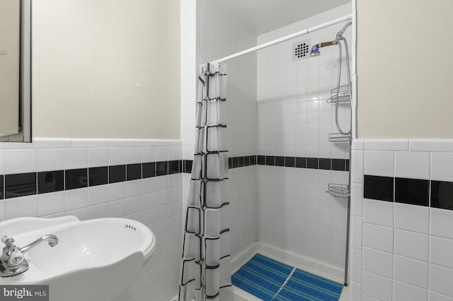 bathroom featuring tile walls, sink, and a shower with shower curtain