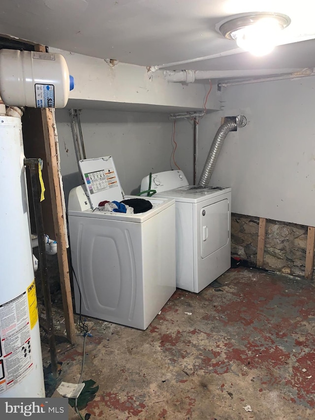 washroom with water heater and washing machine and clothes dryer