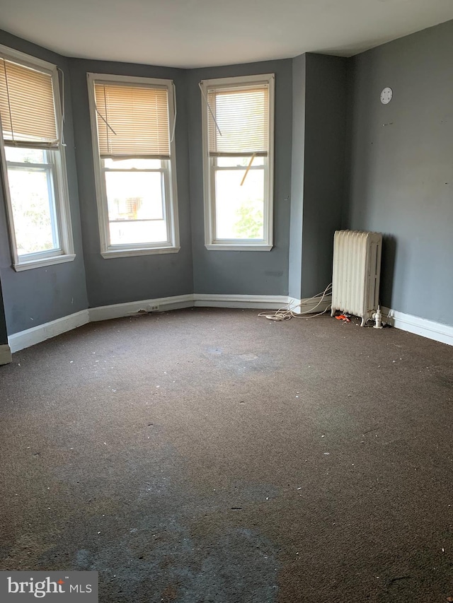 unfurnished room with carpet floors and radiator