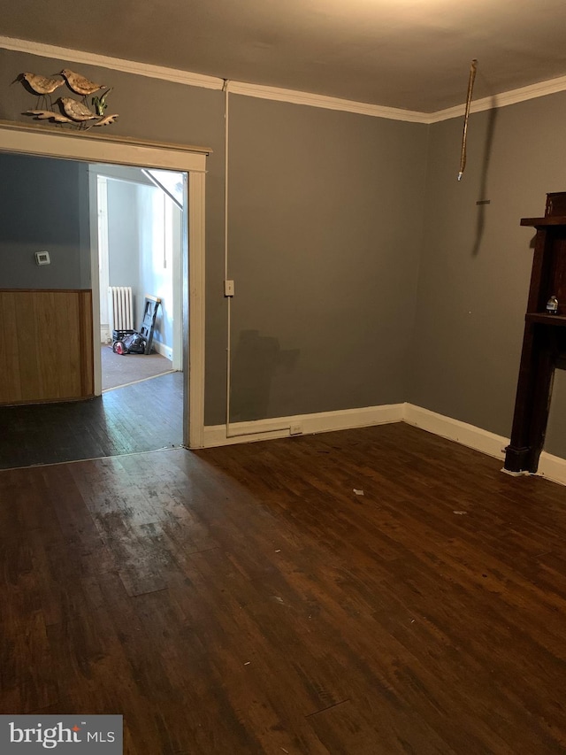 spare room with ornamental molding and dark hardwood / wood-style floors