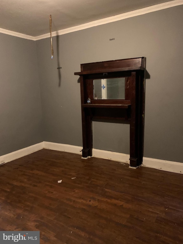 spare room featuring ornamental molding and dark hardwood / wood-style floors