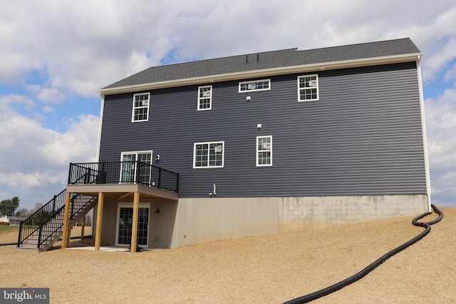 rear view of house featuring a wooden deck