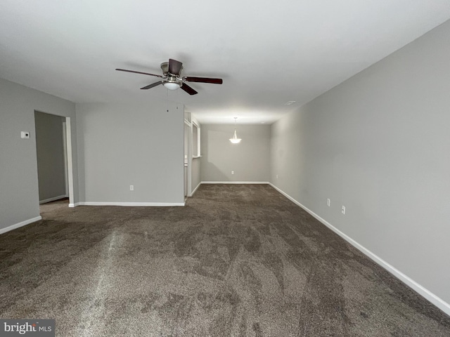 spare room with dark carpet and ceiling fan