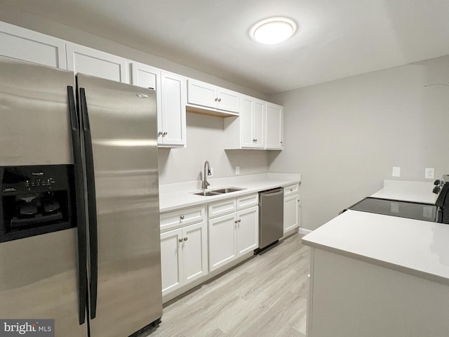 kitchen with white cabinetry, light hardwood / wood-style floors, sink, and stainless steel appliances