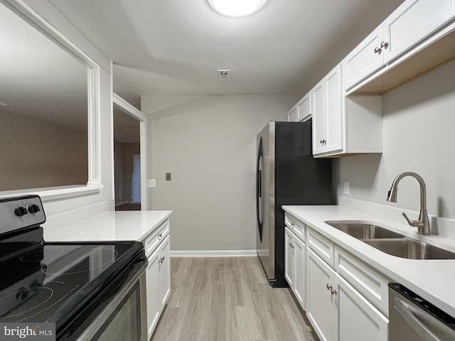 kitchen featuring stainless steel appliances, light hardwood / wood-style flooring, white cabinetry, and sink