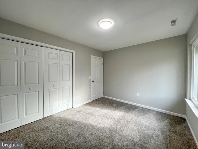 unfurnished bedroom featuring carpet flooring and a closet