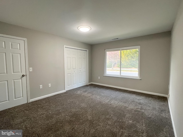 unfurnished bedroom featuring dark carpet