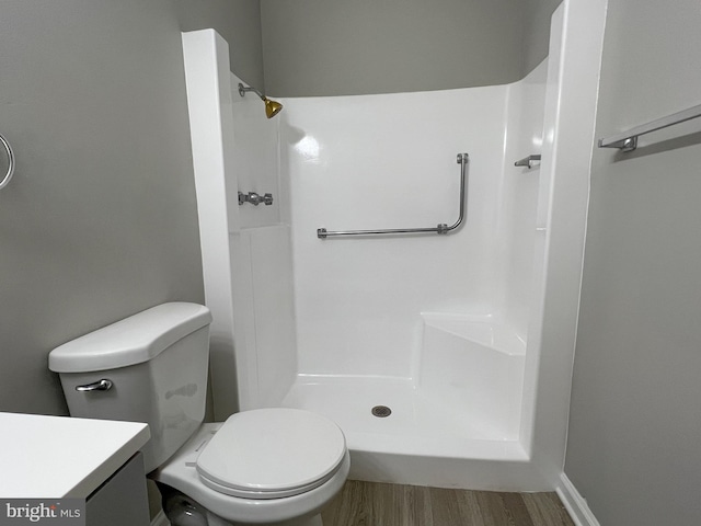 bathroom with a shower, toilet, vanity, and hardwood / wood-style floors