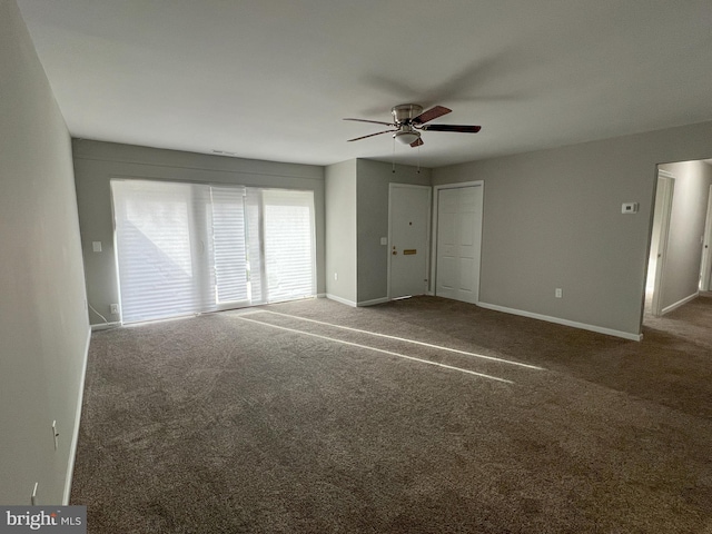 unfurnished bedroom featuring ceiling fan and dark carpet