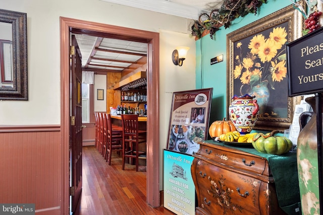 hall featuring dark hardwood / wood-style flooring, crown molding, a baseboard radiator, and beamed ceiling