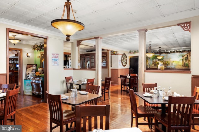 dining space with ornamental molding, dark hardwood / wood-style flooring, and ornate columns