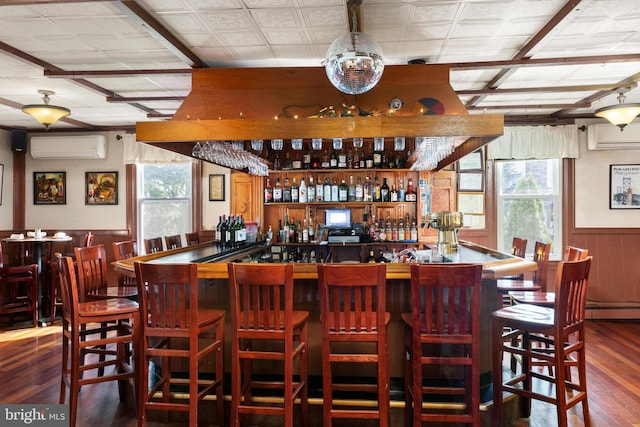 bar with baseboard heating, a wall mounted AC, and dark hardwood / wood-style flooring