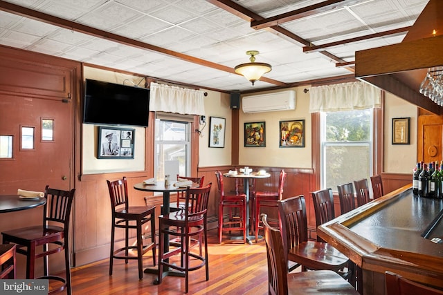 dining room featuring hardwood / wood-style floors and an AC wall unit