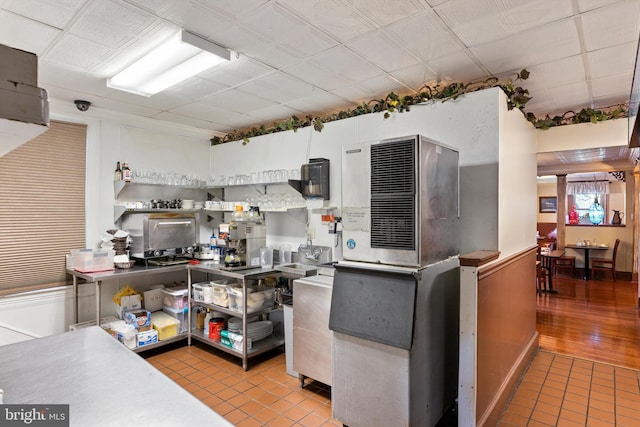 kitchen featuring a paneled ceiling and light tile flooring