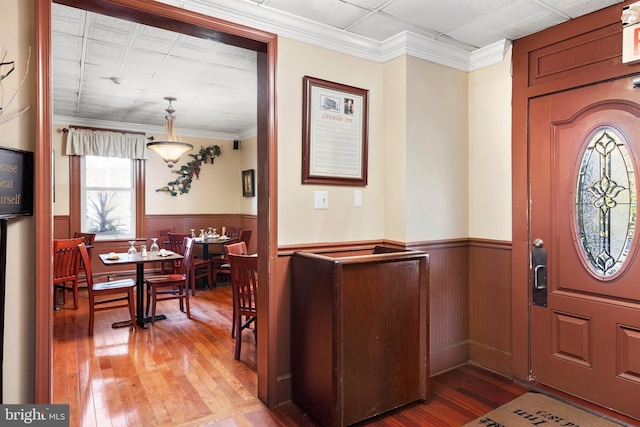 entrance foyer with hardwood / wood-style flooring and crown molding