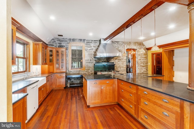 kitchen featuring pendant lighting, dark wood-type flooring, wall chimney exhaust hood, dishwasher, and sink