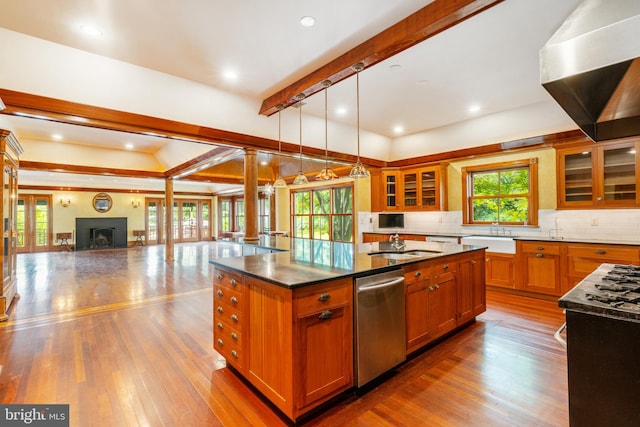 kitchen with an island with sink, hardwood / wood-style floors, dishwasher, tasteful backsplash, and decorative light fixtures