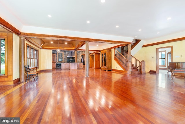 unfurnished living room with hardwood / wood-style floors and ornate columns