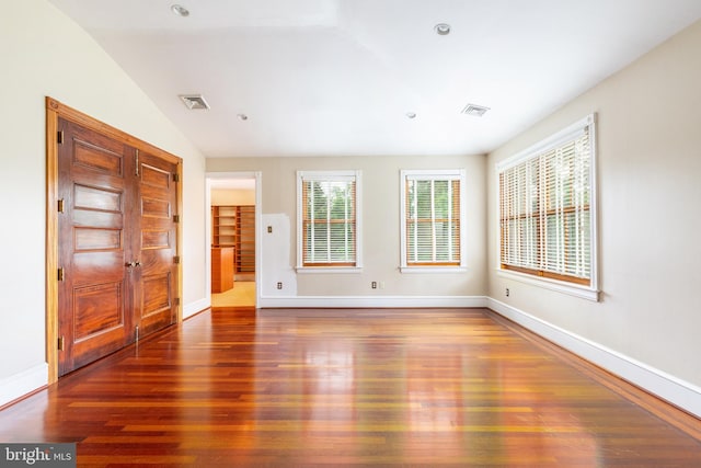 unfurnished room with vaulted ceiling and dark hardwood / wood-style floors