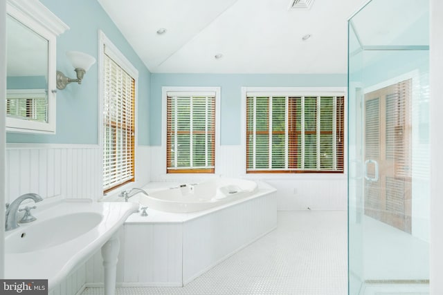 bathroom with a washtub, sink, and tile flooring