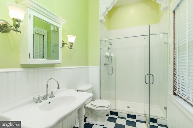 bathroom with sink, tile floors, toilet, and a shower with door